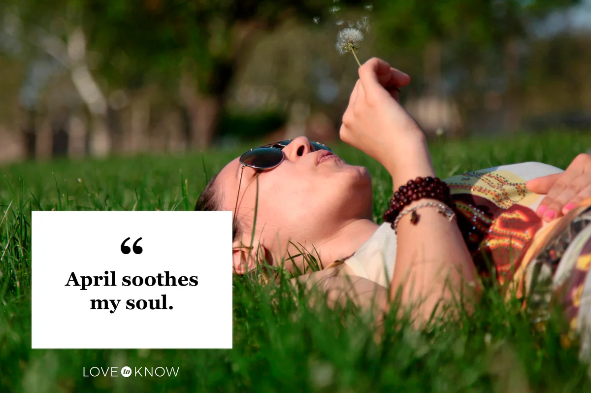 woman lying in grass blowing on a dandelion