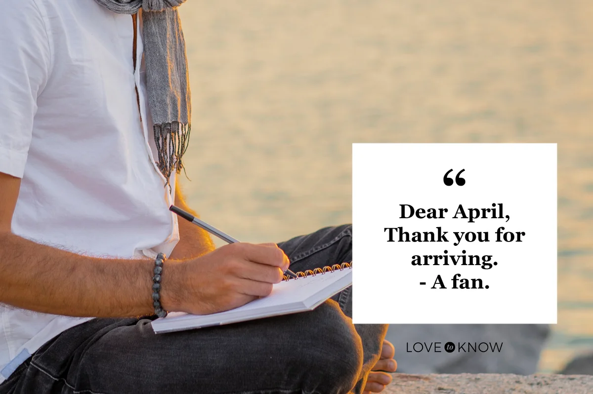 man writing in journal at beach