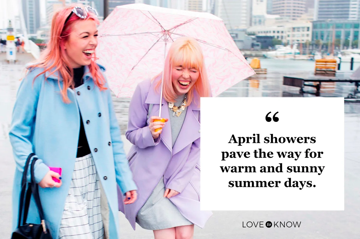 two laughing women walking down street in rain