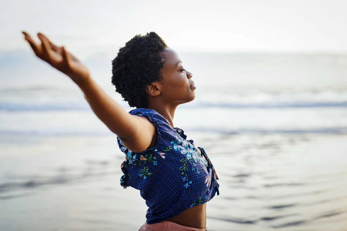 woman with arms outstretched  feeling free at beach