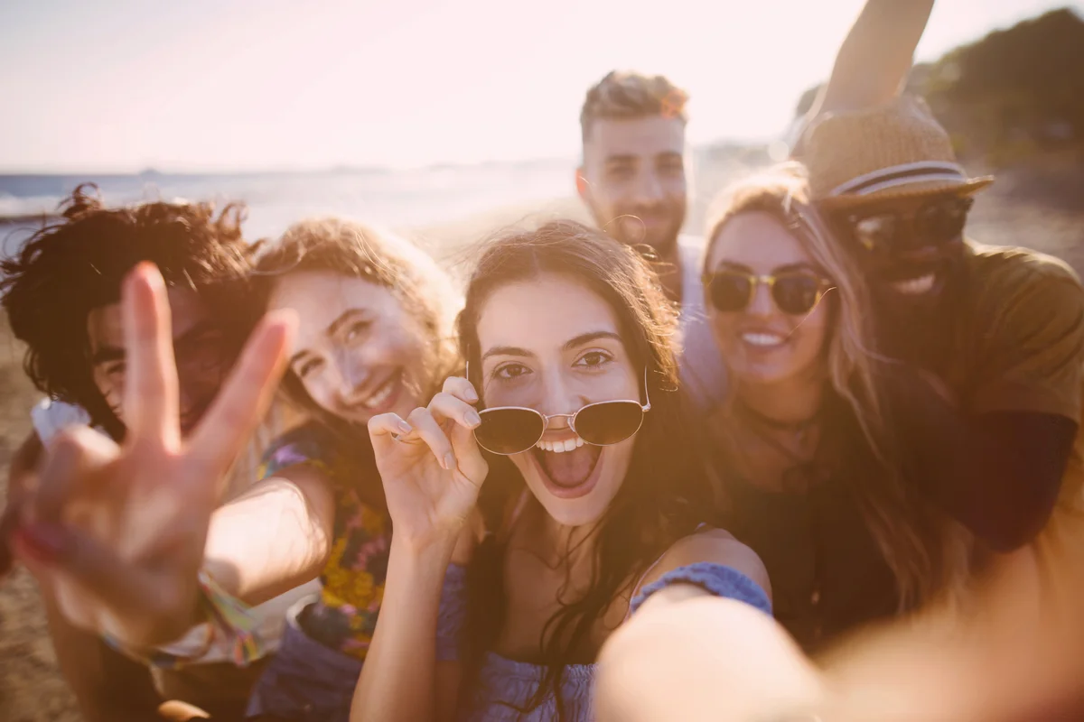 Friends taking selfies at the beach on summer holidays