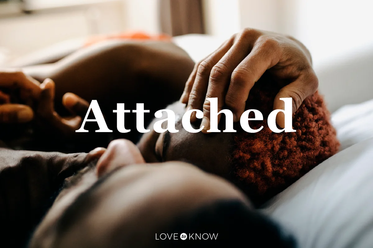 Two Men Embracing While Laying In Bed Together