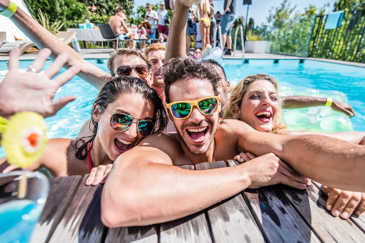 Group of young friends taking selfie at pool side during pool party