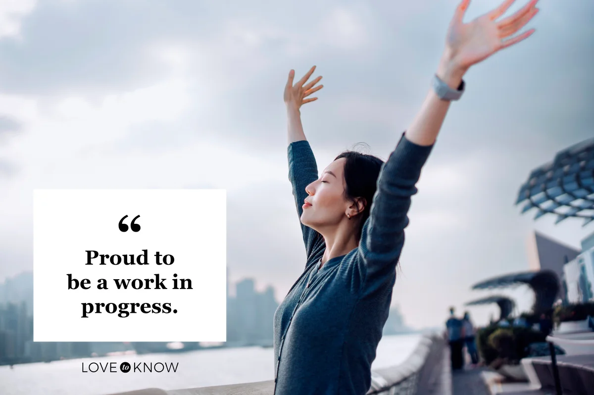 woman with hands up facing sky
