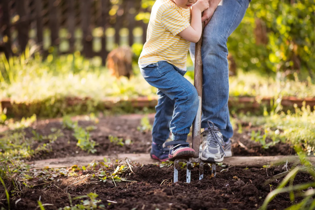 Girl kid helping her mother in garden