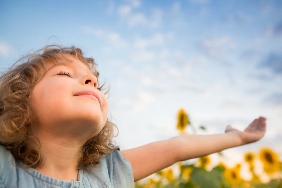 thankful girl holding arms open to sky