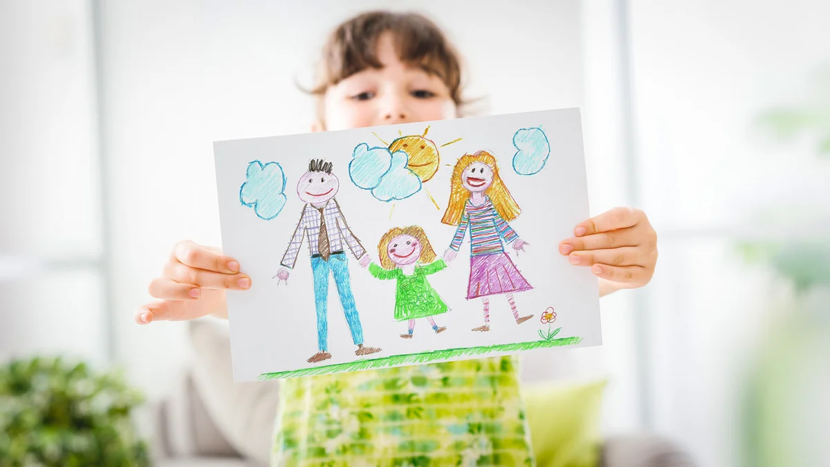 girl holding a drawing of her family