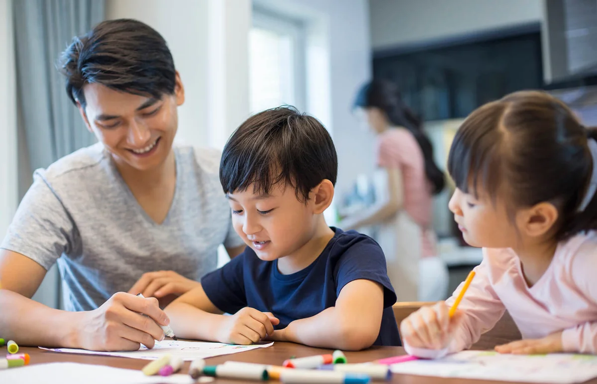 Happy siblings studying together at home