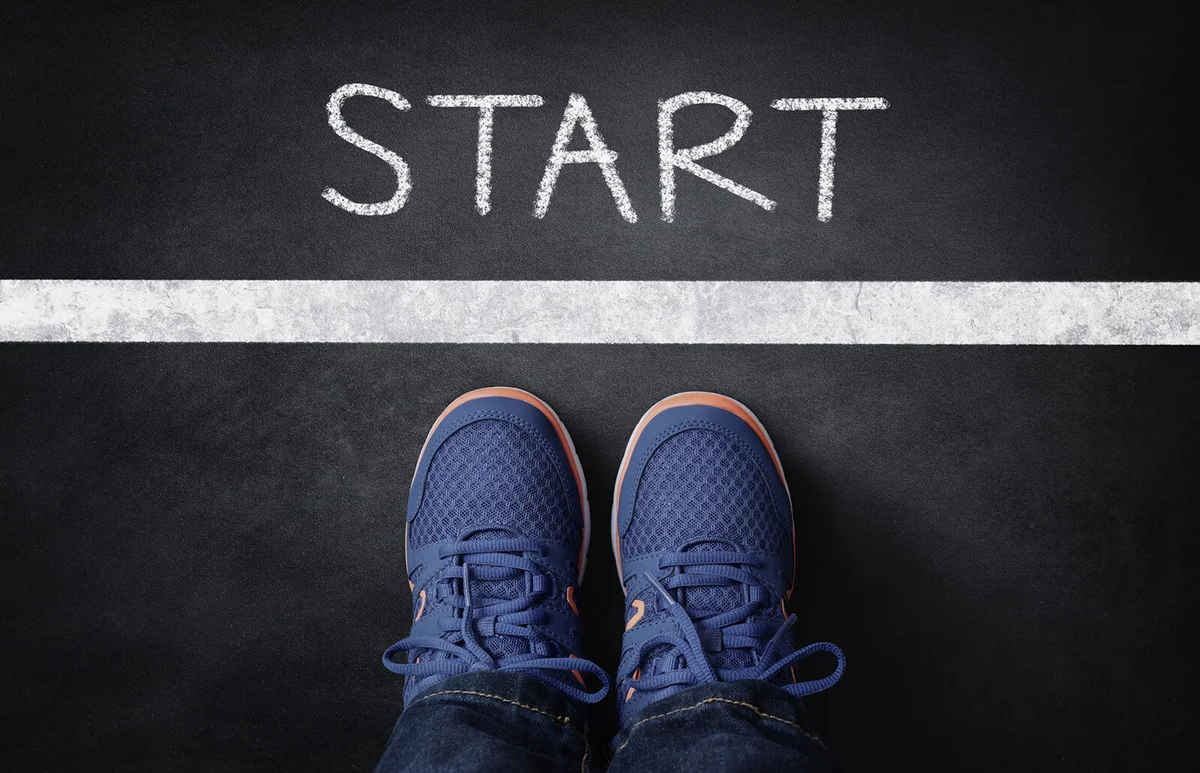 Start line child in sneakers standing next to chalk starting line