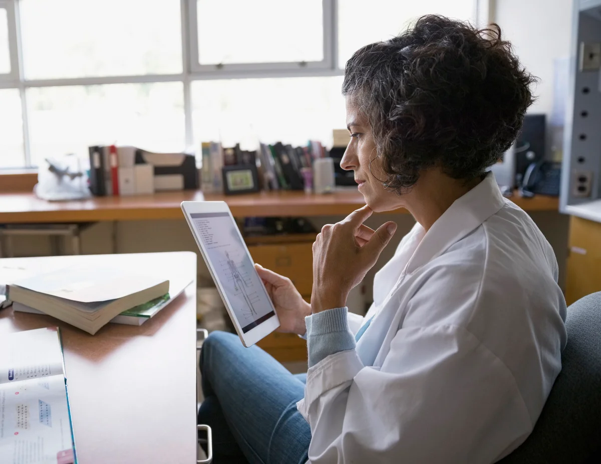 teacher using digital tablet at desk