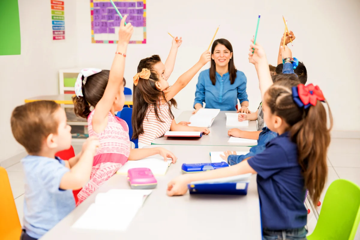 Kids raising their hands at school