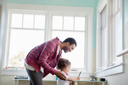 Father assisting daughter with homework