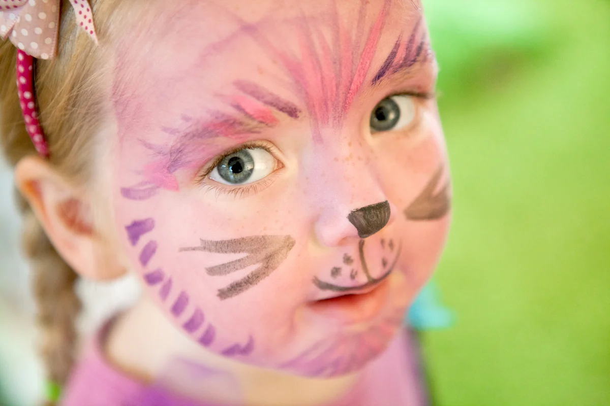 Young Girl with her Face Painted Like a Cartoon Cat