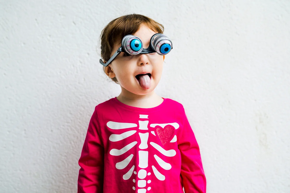 Girl wearing skeleton costume with fake horror eye glasses