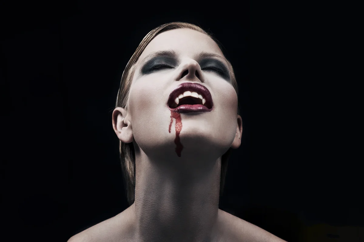 A provocative female vampire with blood running down her chin