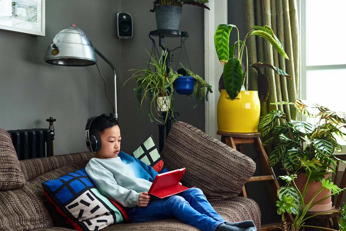 Boy wearing headphones watching movie on tablet