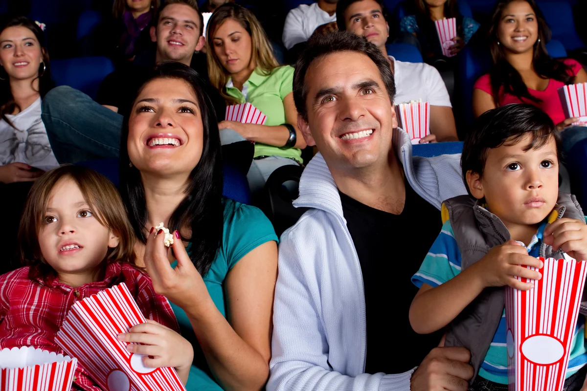 family enjoying movie at theater