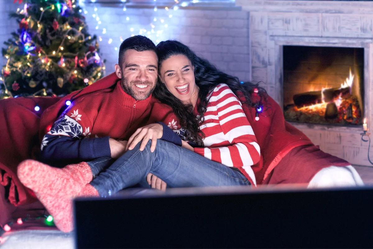 couple laughing and watching Christmas movie