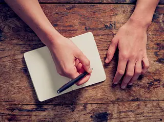 Woman writing on notepad