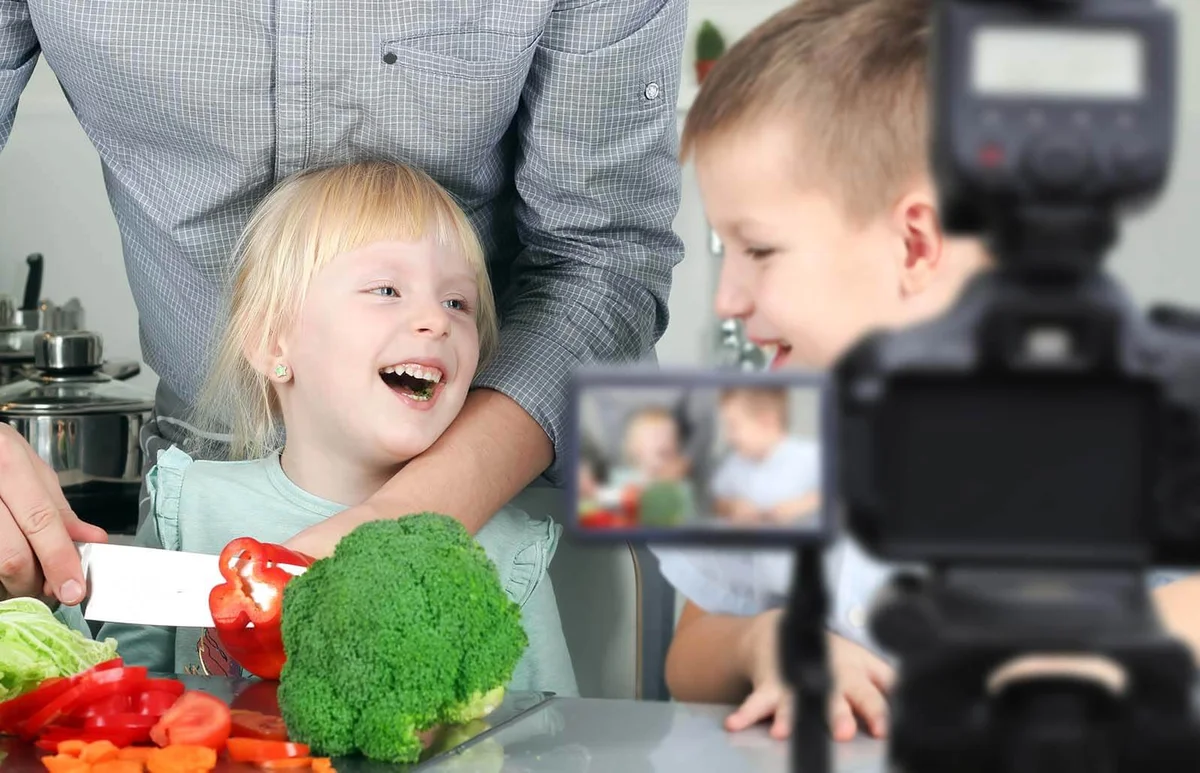 man with children filming the meal preparation