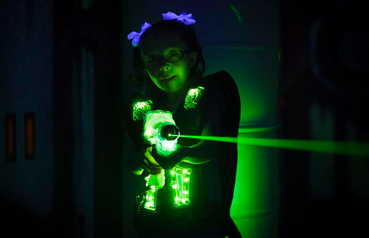 A little girl playing laser tag