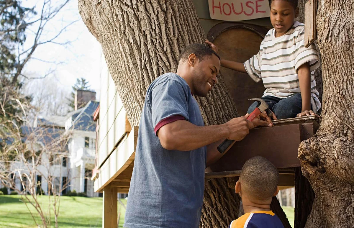 Father and sons building tree house