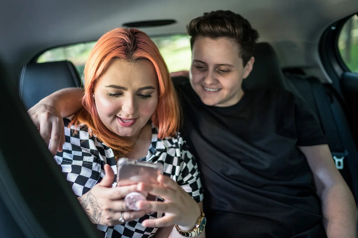 couple using mobile phone inside the car