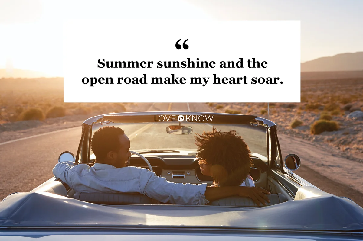 Couple On Road Trip Driving Classic Convertible Car Towards Sunset