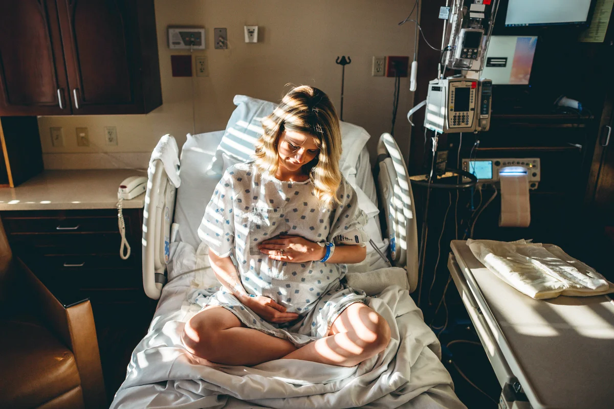 Pregnant woman in hospital touching her bump