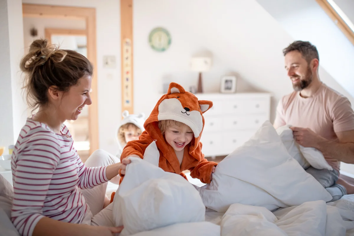 Family making a bed all together
