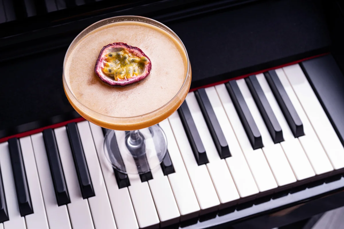 Pornstar Martini cocktail garnished with half of a passionfruit on a piano