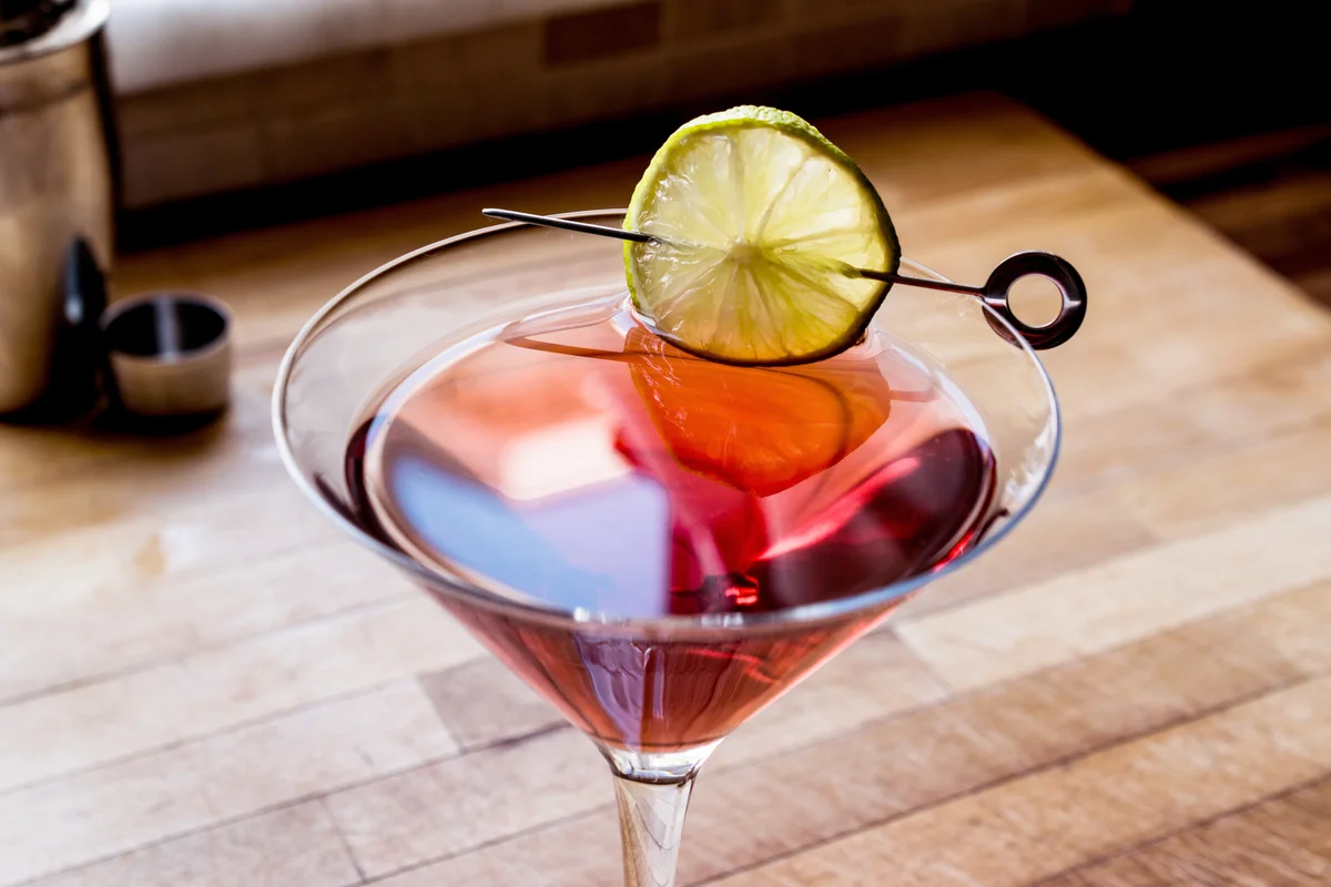 Cosmopolitan Mocktail with shaker on wooden surface