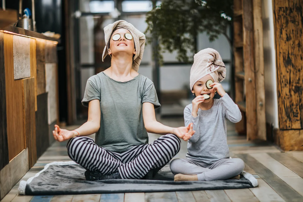 Relaxed mother and daughter exercising Yoga in the morning at home