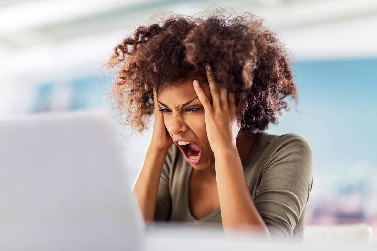 Angry African American woman using computer