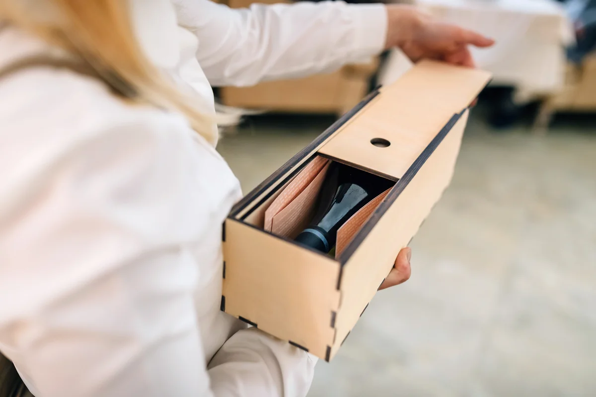 Woman holding wine in a wooden box