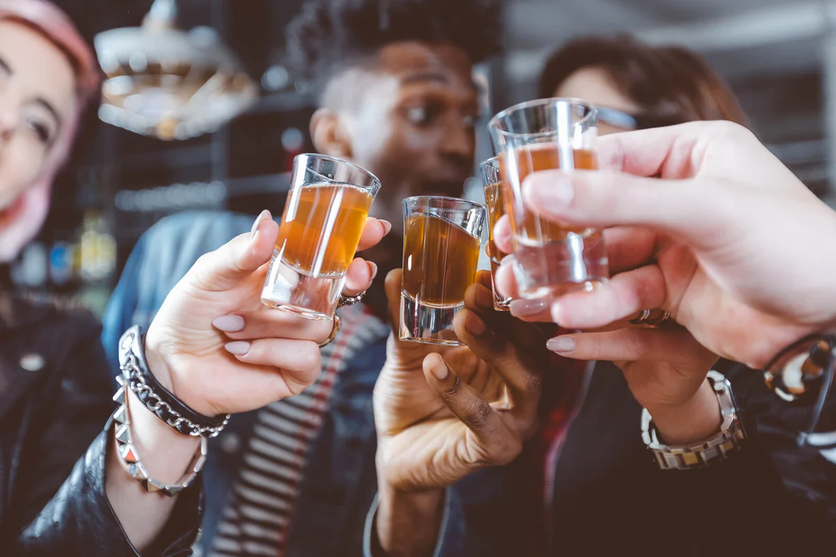 Happy friends drinking shots