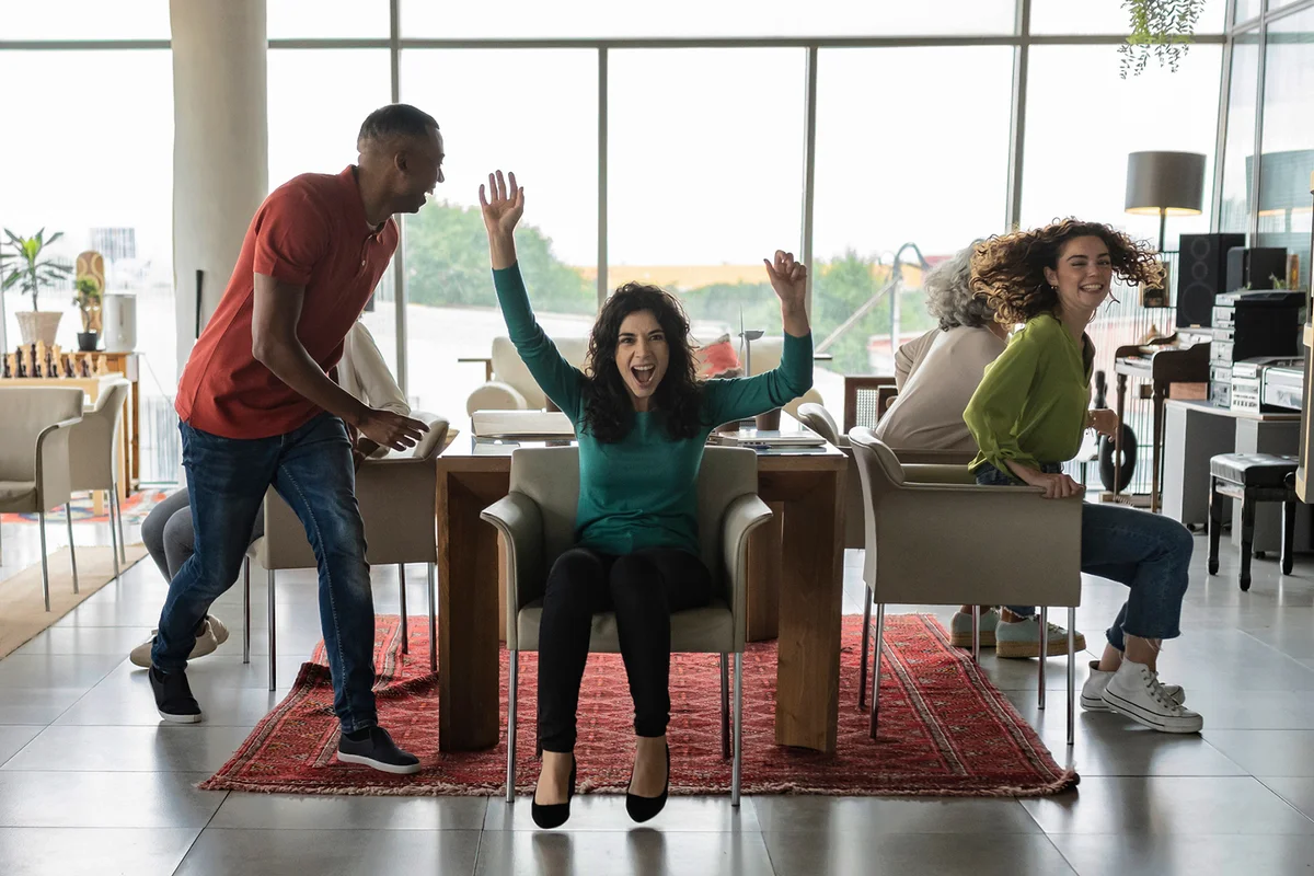 Cheerful friends playing musical chairs