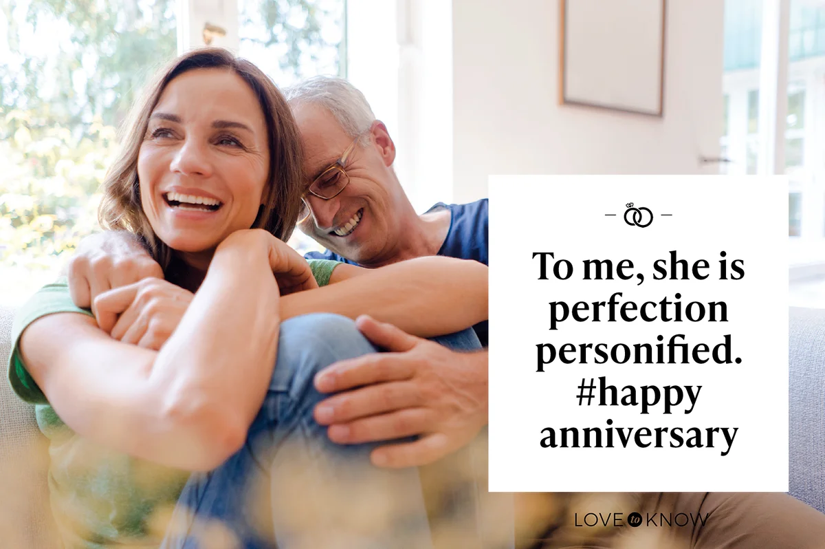 Happy married couple sitting on couch at home