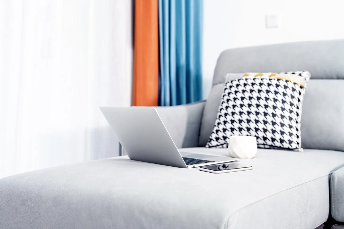 Laptop and coffee cup on sofa-bed at home office