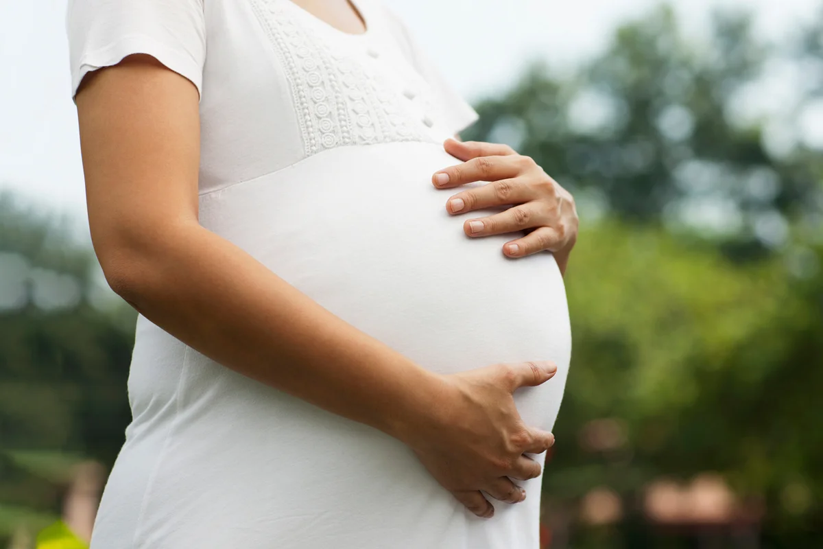 Young pregnant woman touching her belly