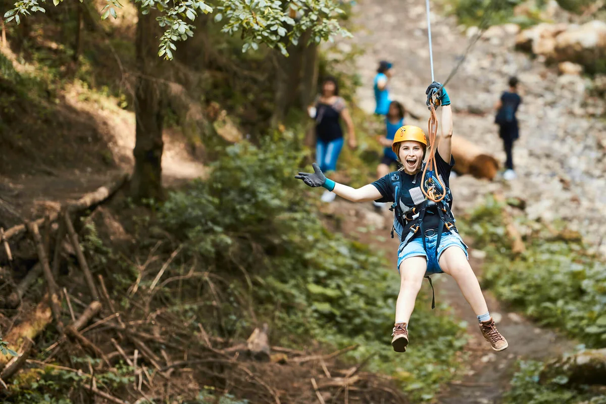 happy woman on tyrolean traverse enjoying adventure