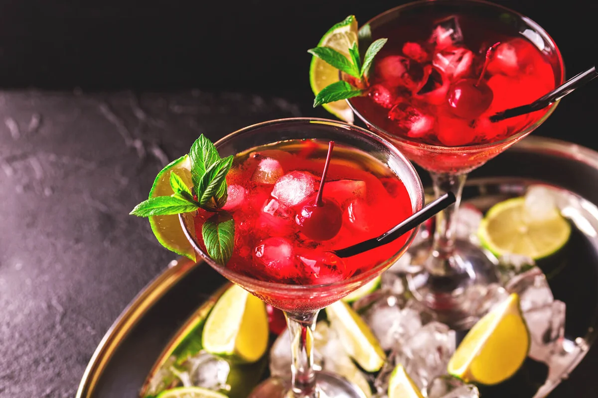 Strawberry daiquiri cocktail with lime, strawberry syrop, cherry and mint