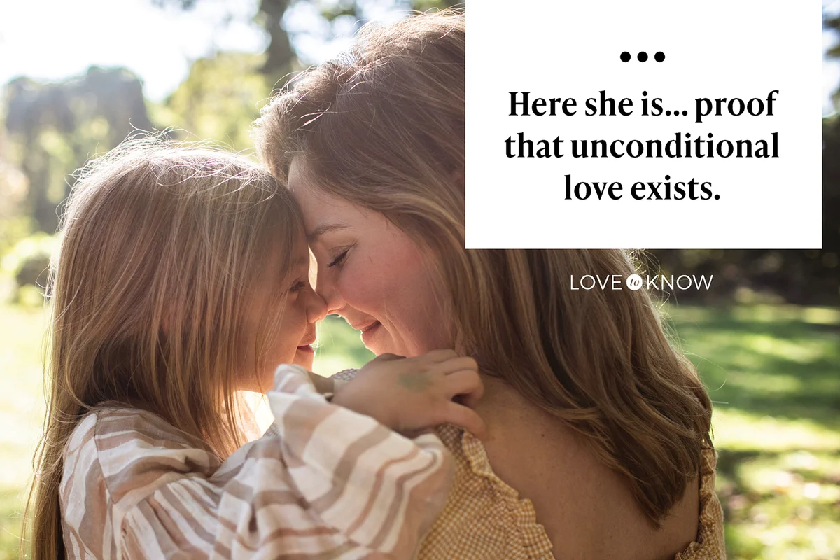 Mother and daughter embracing in rural pasture