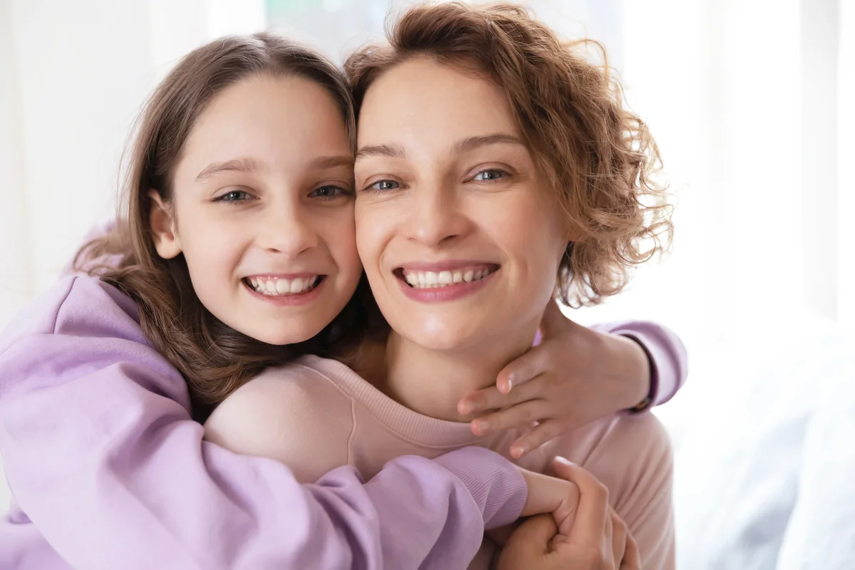 Affectionate teen girl hugging her mother