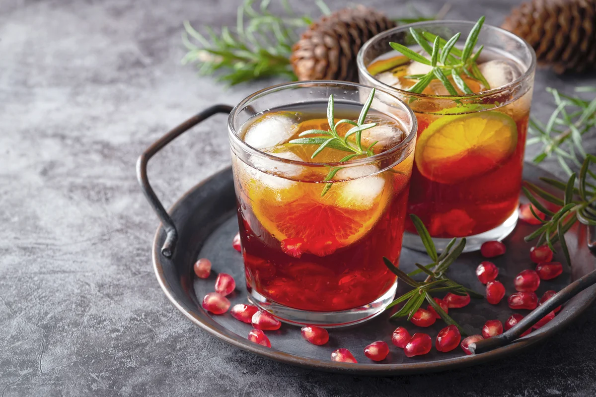 Pomegranate cocktail decorated with lime, rosemary and Ice