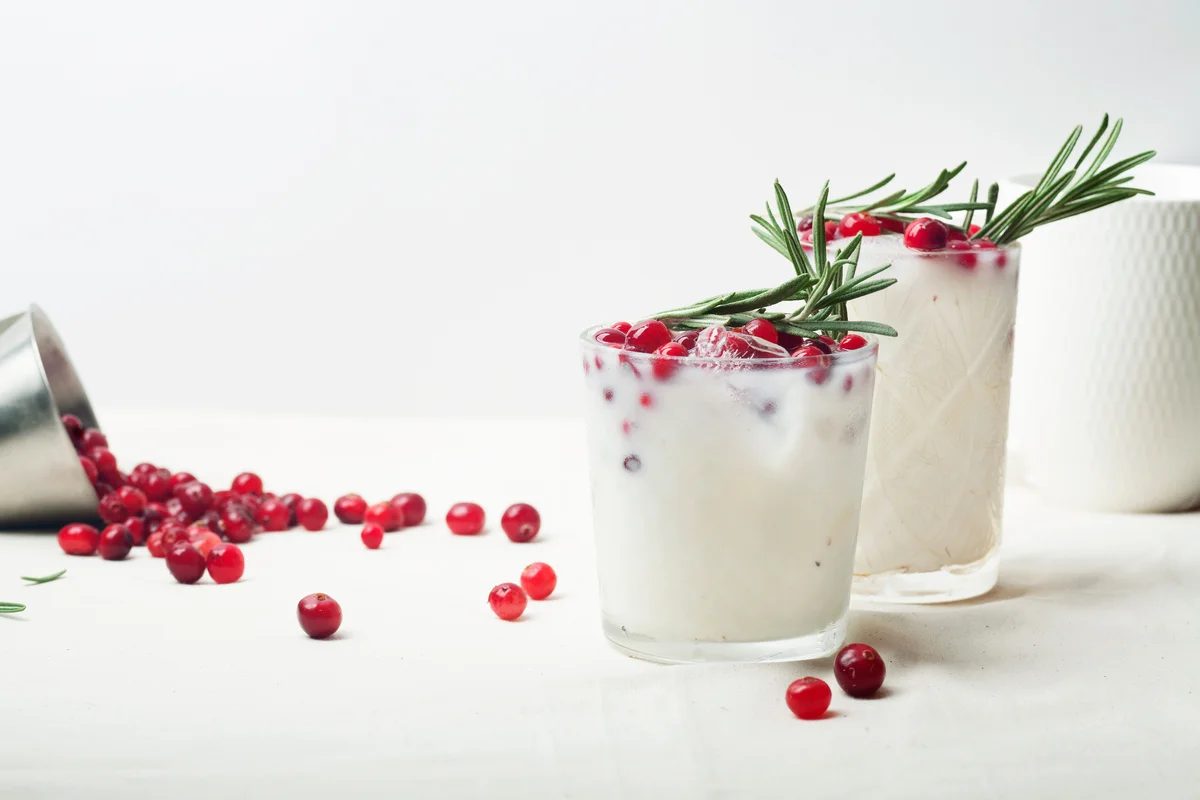 Coconut margarita with cranberries and rosemary
