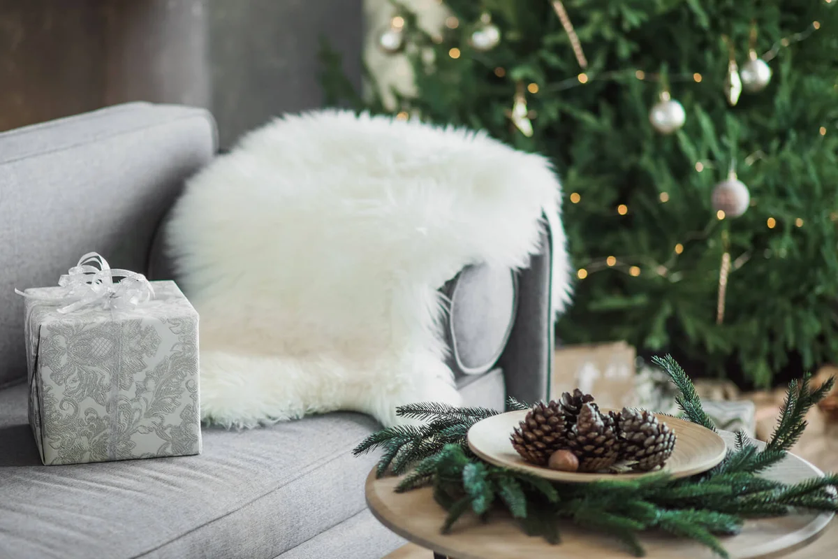 Wrapped gift on the sofa near christmas tree