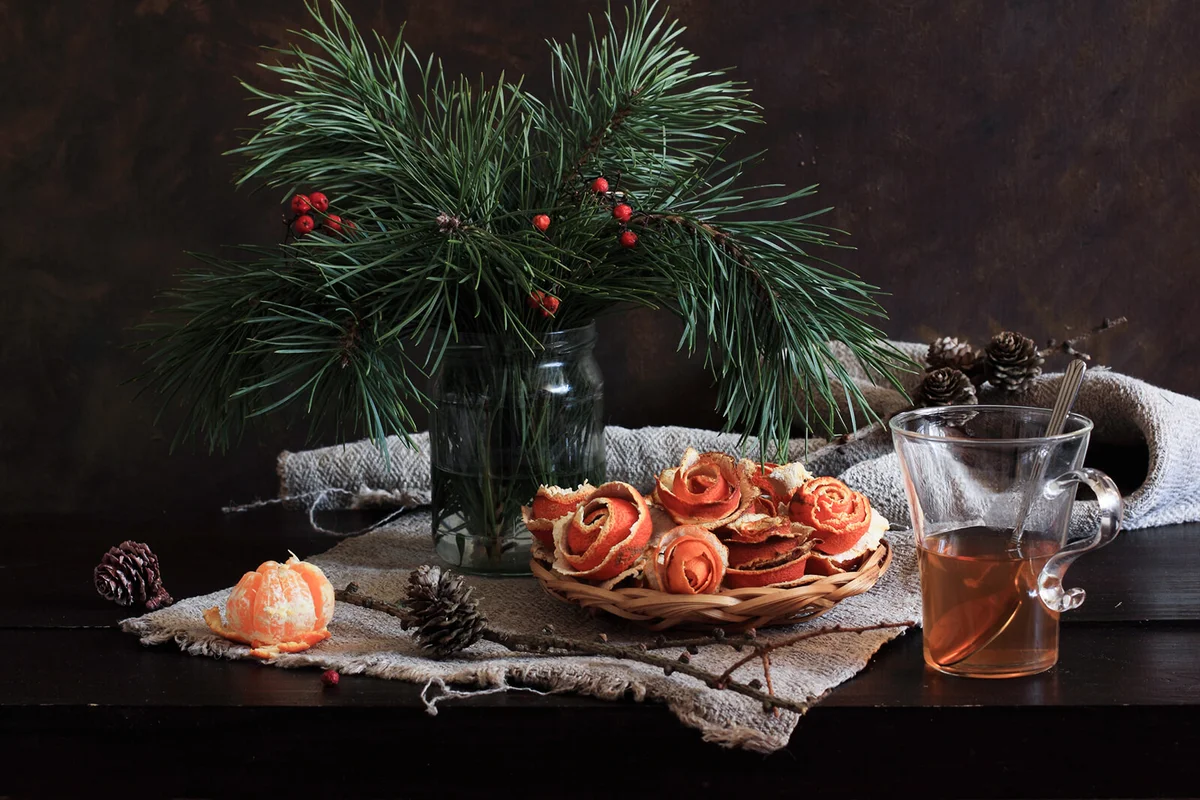A late December fruit-and-branches still life on a table top