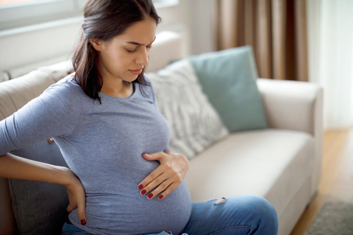 Young pregnant woman suffering from cramps