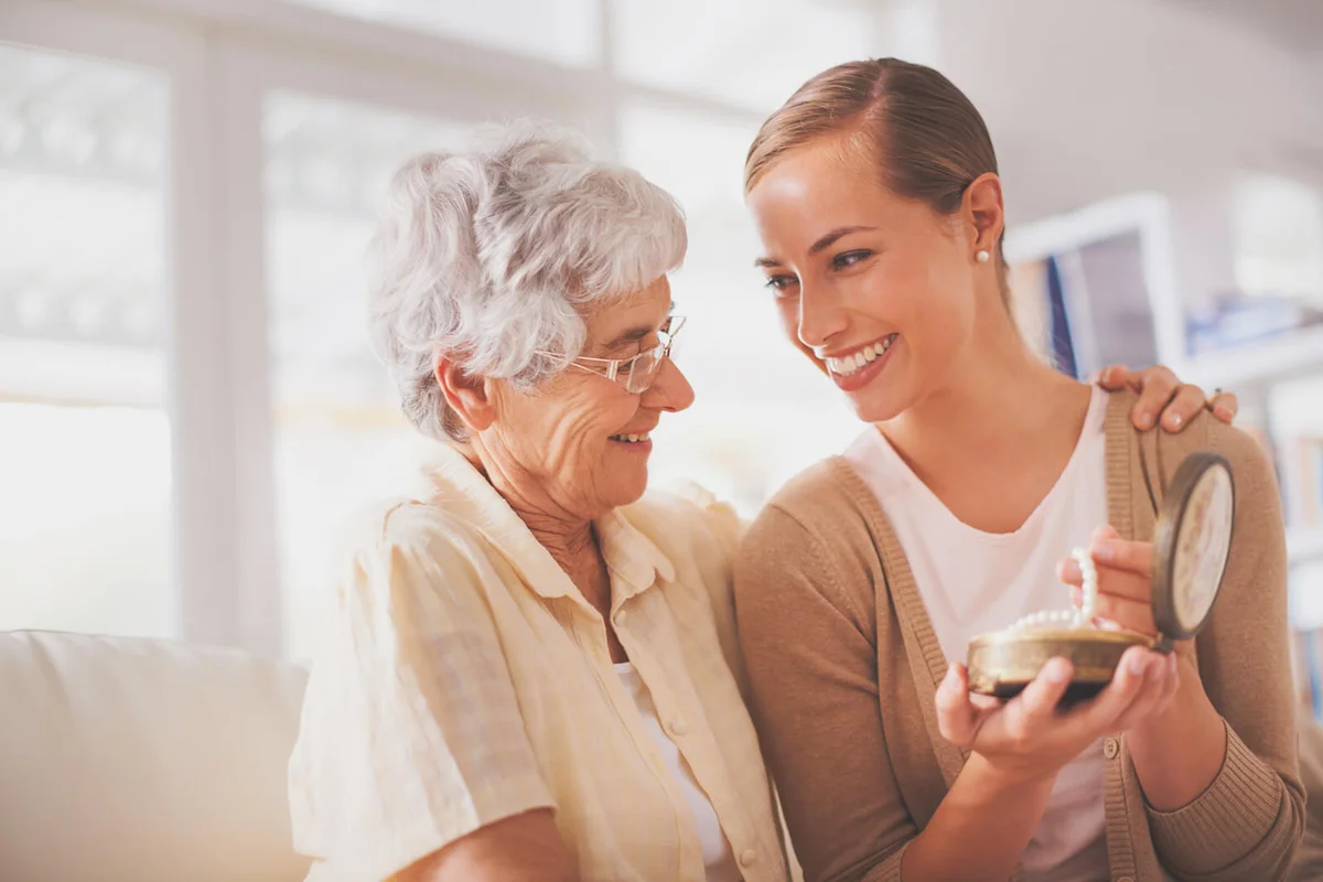 woman giving her daughter a pearl necklace